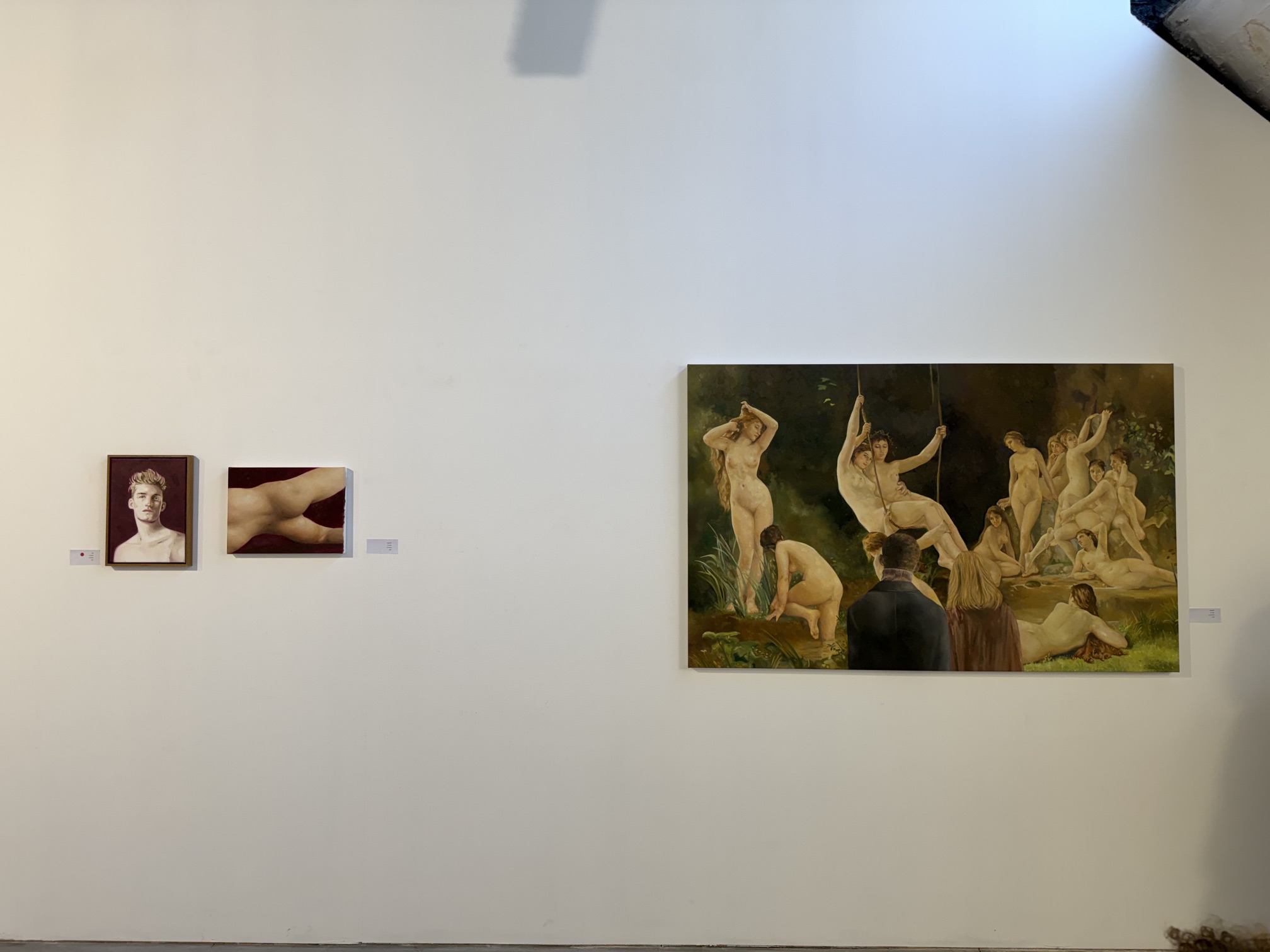 Installation view with a large museum-scene painting and adjacent works.