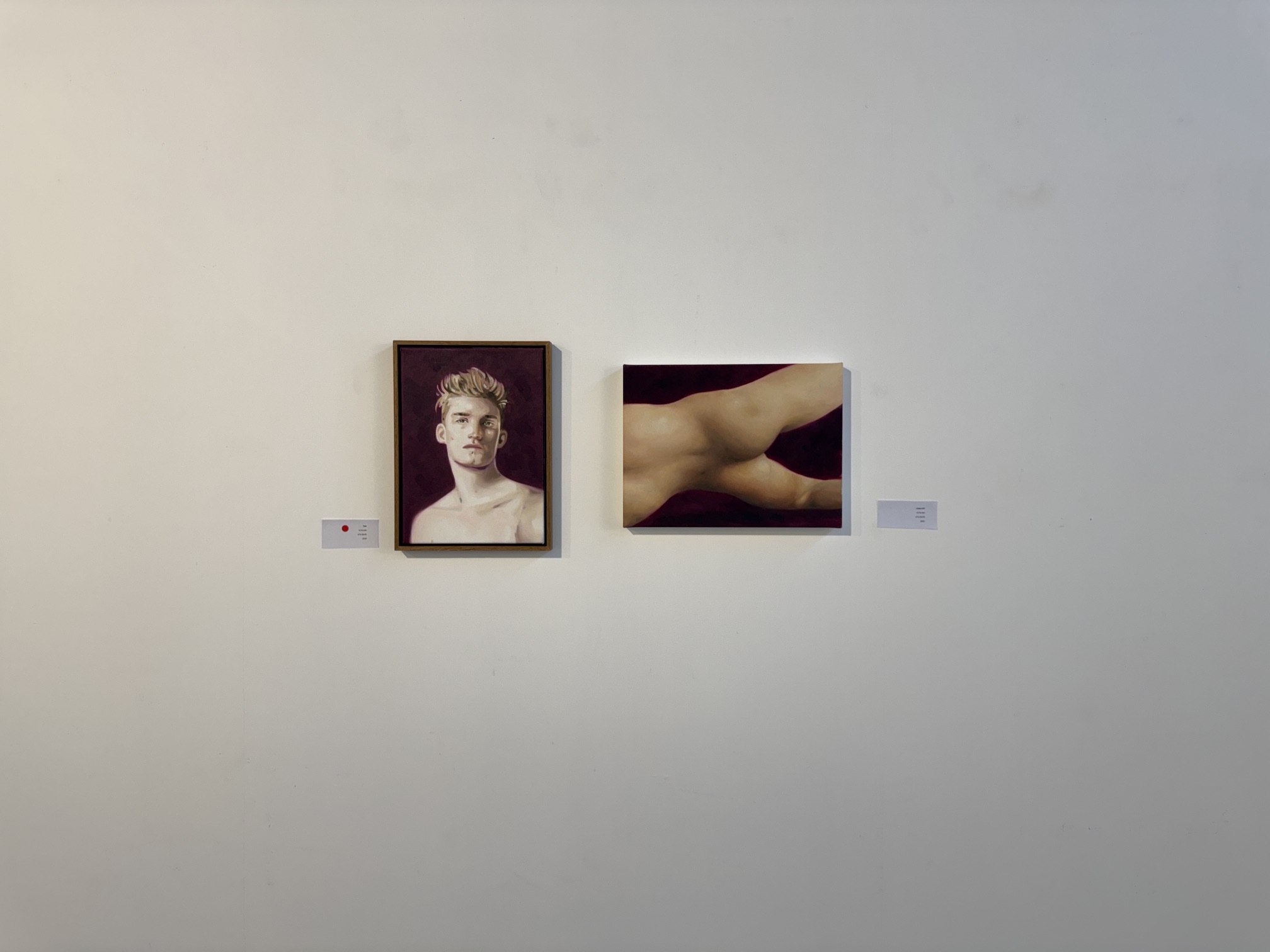 Installation view pairing a portrait with a figure study.