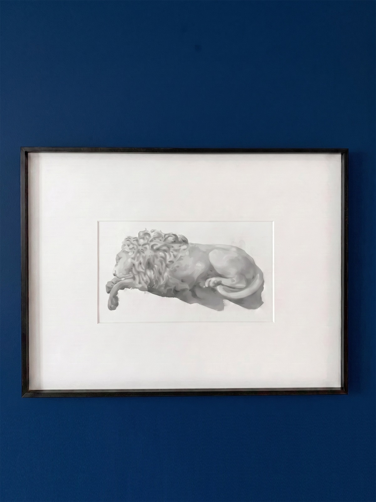 A monochromatic reclining figure study displayed on a blue wall.