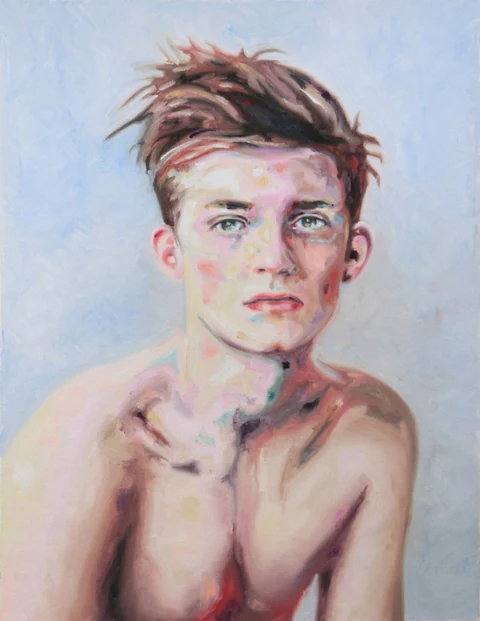 Bare-chested young man shown from the waist up against a pale blue background.