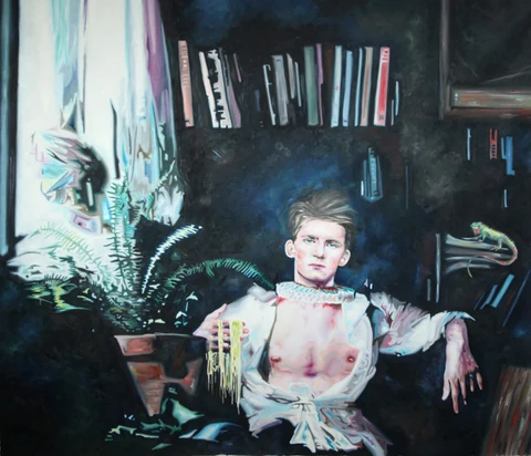 Bare-chested young man seated in a dark interior with books and plants behind him.