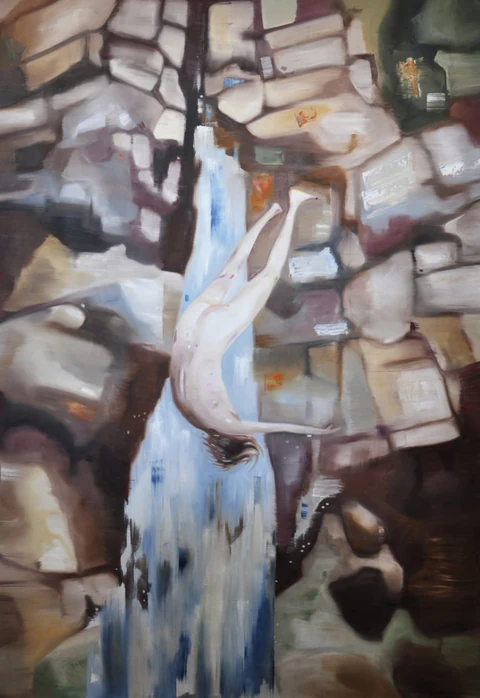 White bird descending beside angular rocks and falling water.