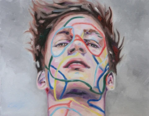 Close-up of a young man's face marked with colored linear patterns.