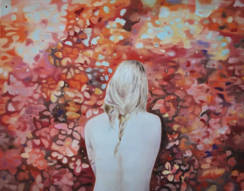 Blond figure seen from behind against dense red and orange foliage.