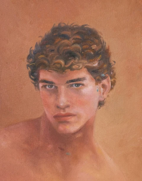 Portrait of a young man turning toward the viewer against a muted green background.