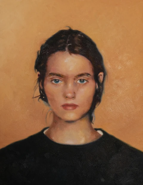 Frontal portrait of a dark-haired figure in a black top against a warm ochre background.