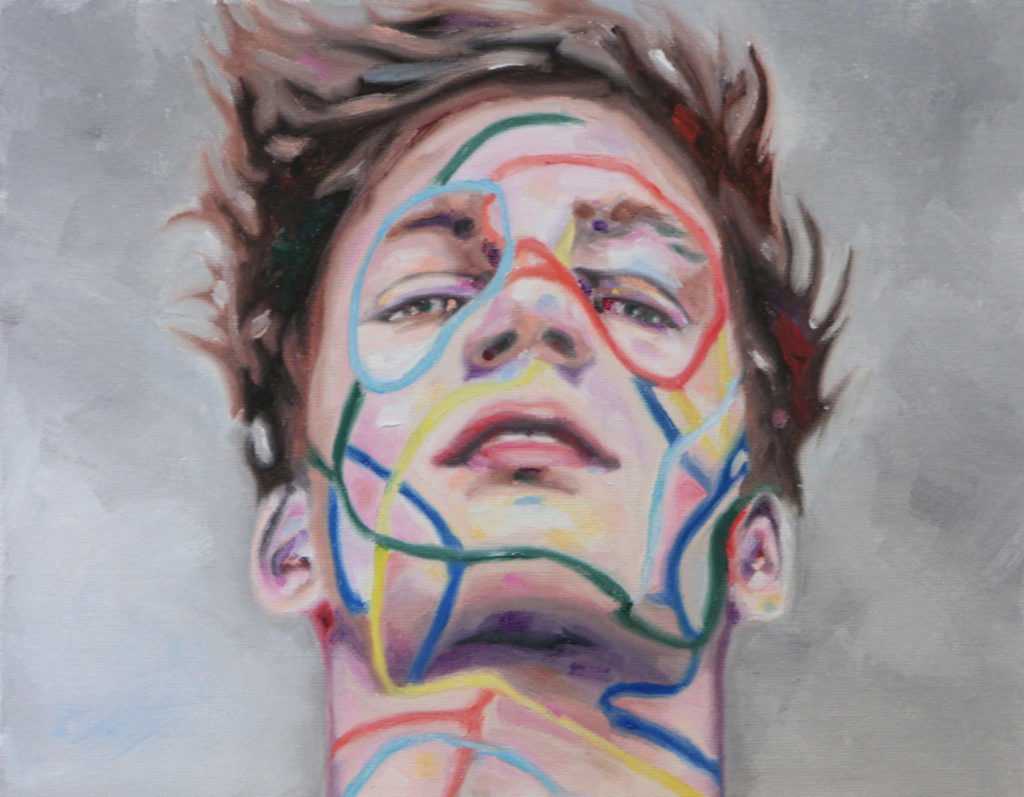 Close-up of a young man's face marked with colored linear patterns.