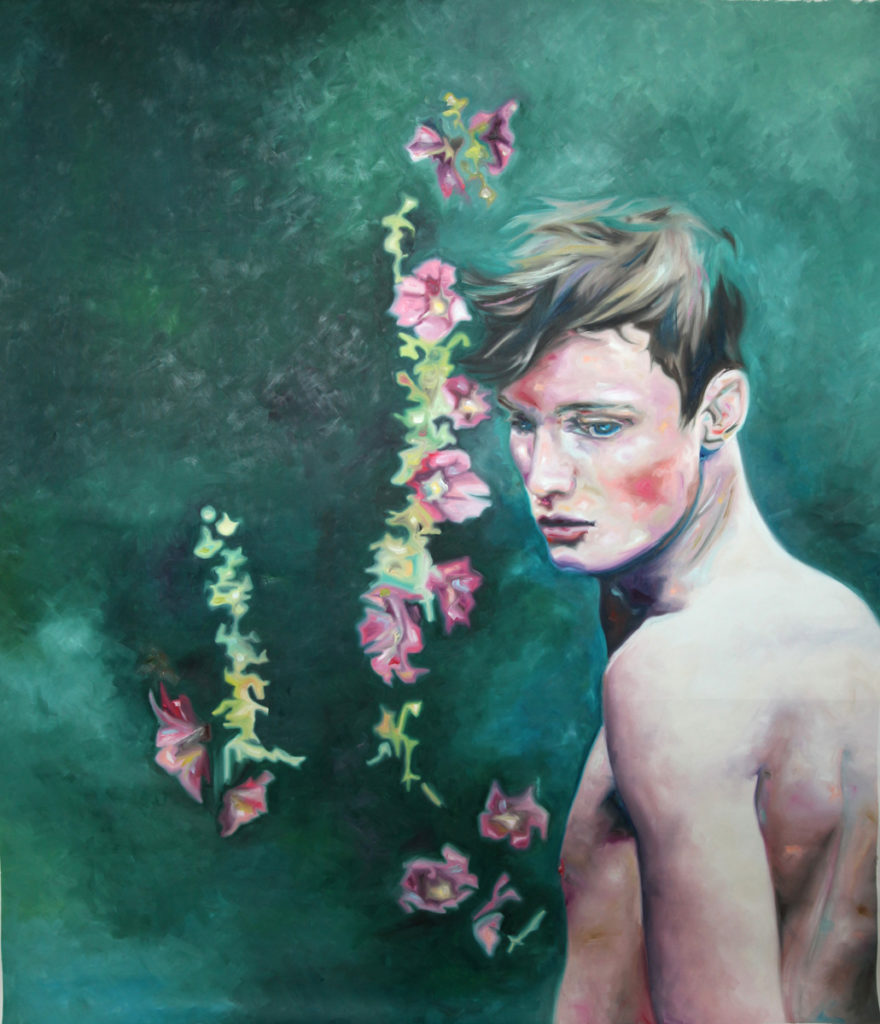 Bare-chested young man turning beside a vertical spray of pink flowers.