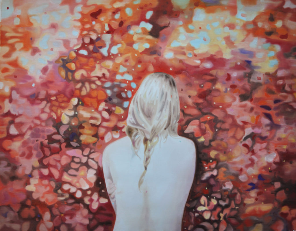 Blond figure seen from behind against dense red and orange foliage.