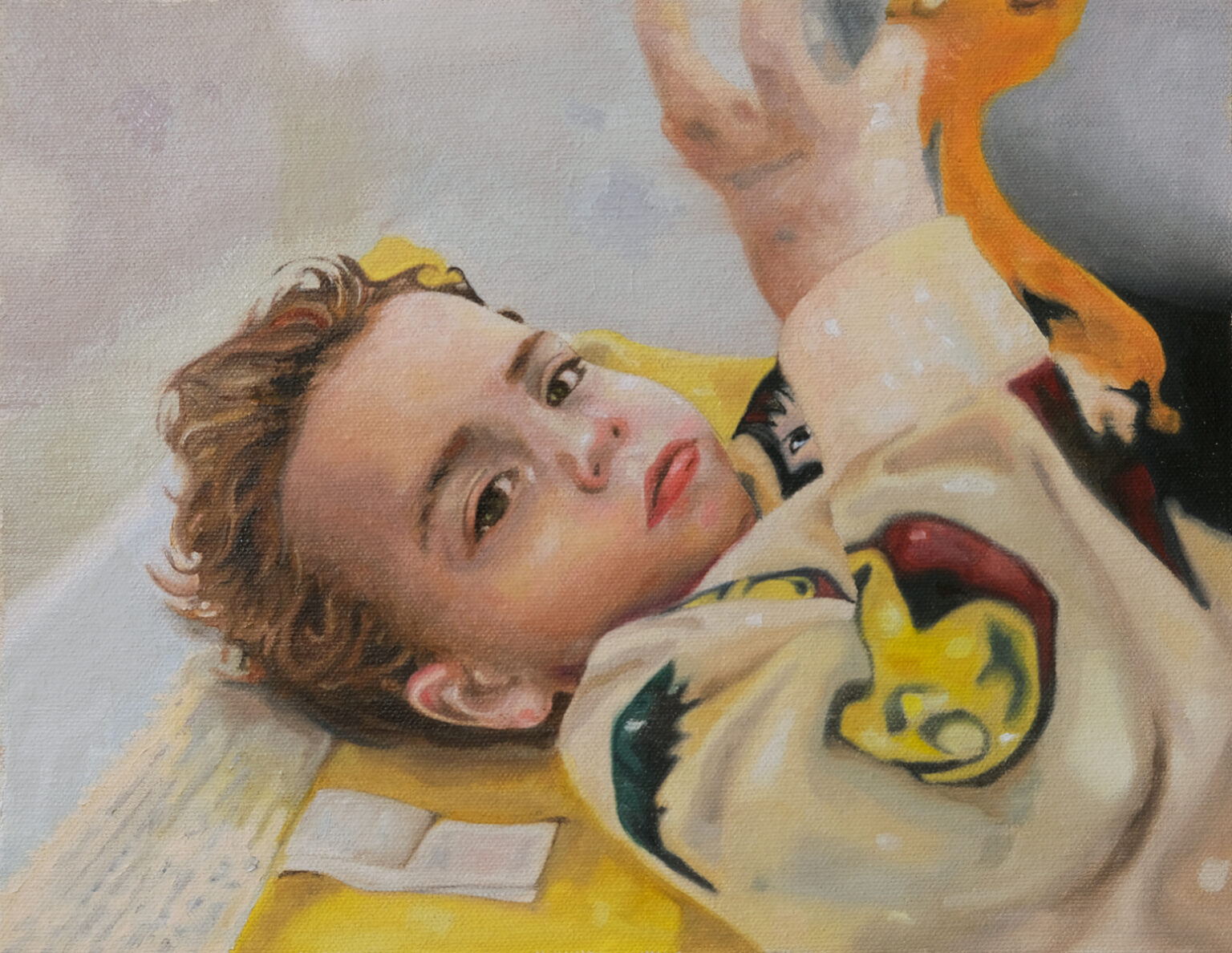 Young person reclining on a bed and reaching upward.